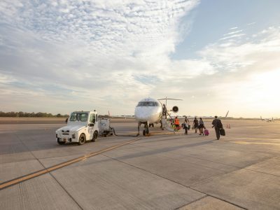 Des passagers montent à bord d'un jet privé sur une piste d'aéroport.