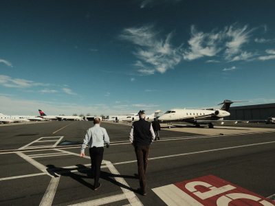 Deux hommes marchant vers des avions dans un aéroport.