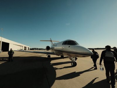 Des passagers marchent autour d'un petit jet sur le tarmac.